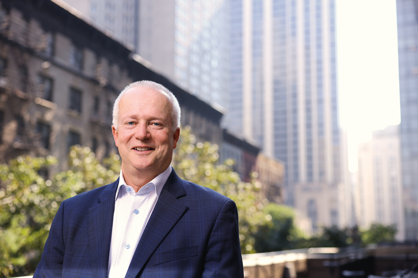 Dean Robert A. Harrington, M.D., with buildings behind him.