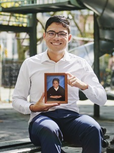Dr. Felipe Camelo at playground holding childhood photo of himself.