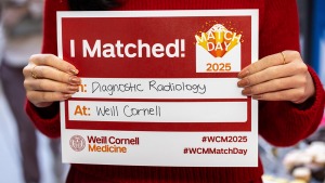 Closeup of hands holding sign reading, “I Matched! In: Diagnostic Radiology, At: Weill Cornell”