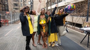 A group of five young Black women celebrate together. 