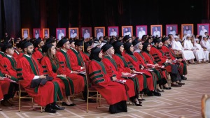 Medical school students in Qatar seated in red gowns and black caps during their commencement