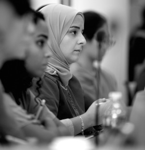 Female medical student in hijab, seen in profile, attends lecture with other medical students.