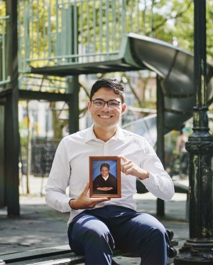 Dr. Felipe Camelo at playground holding childhood photo of himself