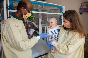 Male doctor with female doctor holding infant