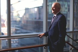 Dean Robert A. Harrington, M.D., in profile, smiling as he looks out a window onto the Weill Cornell Medicine campus.